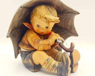 Umbrella Boy" figurine by M.I. Hummel. This figurine is a popular collectible and features a young boy sitting under an umbrella. 
