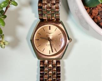 Classic Longines Admiral men’s automatic wristwatch with gold-tone case and bracelet. Champagne dial with date display at 3 o’clock. Keeps time and winds smoothly. Light patina and surface wear consistent with age.