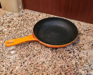 Le Creuset enameled cast iron skillet, likely in the "Flame Orange" 