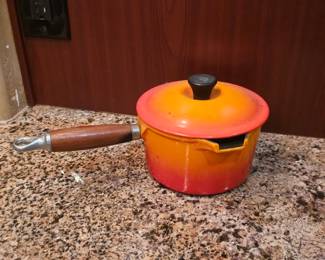vintage Le Creuset or Descoware enameled cast-iron saucepan with a wooden handle, in the "Flame" orange color. 