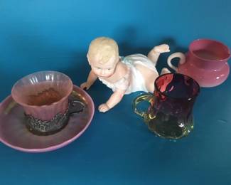 Steuben "Oriental Poppy" cup & saucer, Heubach piano baby, Peachblow creamer & Amberina mug