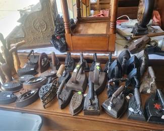 Huge selection of vintage sad irons and cast iron trivets