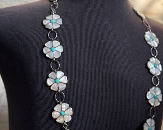 This lot features a vintage Zuni Native American concho belt made of sterling silver with mother-of-pearl and turquoise inlay with a floral design. Measures 42” with a total approx. weight of 196.41 grams.
