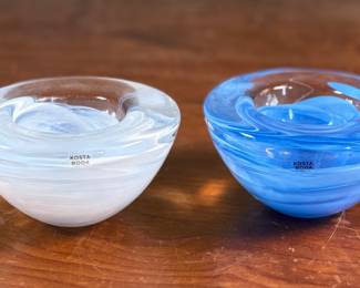 This lot features a set of Kosta Boda Atoll glass votive candle holders, designed by Anna Ehrner, with a white swirl and a blue swirl pattern. Anna Ehrner, born 1948 in Danderyd in Stockholm, is both a designer and glass artist who’s characterized by her simple design language. With an experimental expression, she has an ability to create effectful pieces with only a little color, where lines of color inside the glass has become a recurring feature.

