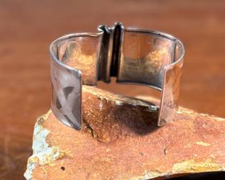 This lot features an artisan made sterling silver cuff, signed by "Cela" as shown in photos with a total approx. weight of 27.33 grams.

