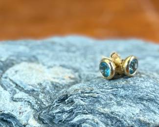 This lot features a pair of beautiful antique 14k gold earrings, each with a center stone that appears to be blue topaz and a total approx. weight of 2.05 grams.
