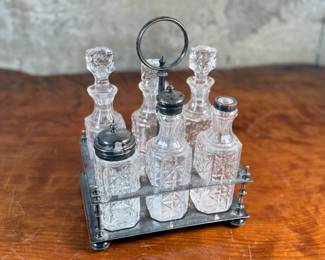 This lot features an antique cruet that appears to be made in the 19th century with six (6) misc. bottles, three of which appear to have silver accents to them. This cruet measures, 10” H x 7.5” W x 5.5” D.
