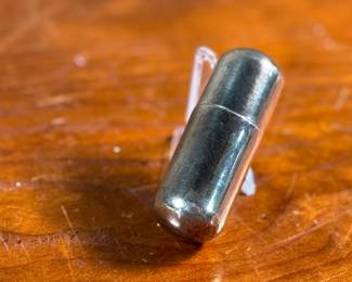 This lot features an antique sterling silver thread holder, manufactured and signed by Napier. The sterling case alone weighs approx. 19.53 grams.
