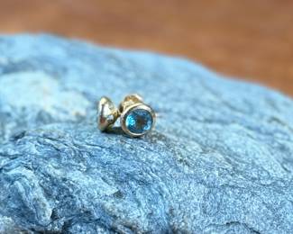 This lot features a pair of beautiful antique 14k gold earrings, each with a center stone that appears to be blue topaz and a total approx. weight of 2.05 grams.
