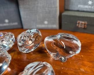 This lot features a collection of five (5) animal themed Steuben Glass sculptures, with five cases to accompany them. Steuben Glass is an American art glass company founded in Corning, New York, in 1903 by Frederick Carder. Originally known for colored glass, it shifted to brilliant clear crystal in the 1930s after being acquired by Corning Glass Works (now Corning Inc.) in 1918. The brand was sold in 2008, production ceased in 2011, and was reacquired by Corning Inc., which now oversees its production and sales through the Corning Museum of Glass.
