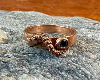 This lot features a 14k rose gold ring with an “octopus” feature and center stone. This ring is a size 6.5 with a total approx. weight of 3.79 grams.
