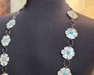 This lot features a vintage Zuni Native American concho belt made of sterling silver with mother-of-pearl and turquoise inlay with a floral design. Measures 42” with a total approx. weight of 196.41 grams.

