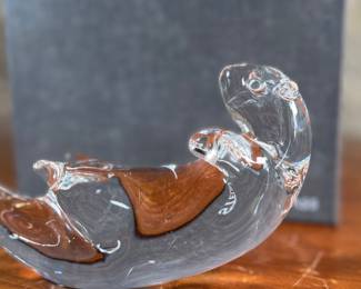 This lot features a Steuben Crystal Glass sea otter figurine, designed by James Houston in 1978. Comes with a Steuben box for storage.

