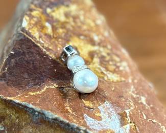 This lot features a 14k gold and pearl snowman pendant with a total approx. weight of 2.00 grams.
