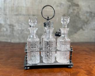 This lot features an antique cruet that appears to be made in the 19th century with six (6) misc. bottles, three of which appear to have silver accents to them. This cruet measures, 10” H x 7.5” W x 5.5” D.
