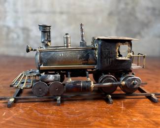 This lot features a unique handcrafted locomotive sculpture made of various metals and salvaged materials. It has a brass plaque mounted on top from Jacksonville, Oregon. This sculpture measures, 6” H x 13” W x 5” D.
