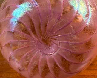 This lot features a stunning vintage pink iridescent vase by Glass Eye Studio, circa 1985. Signed MSH (Mt. Saint Helens) and measures, 4” H x 2.5” W x 2.5” D. Founded in 1978 by a group of glass artist friends, Glass Eye Studio’s first hotshop was nestled in an alley of Seattle’s Pike Place Market. Since its inception over 40 years ago, it continues to thrive with the same passion and revelry for all things glass. As one of the oldest and largest privately-owned hot shops in the country, it’s rich artistic legacy has incubated generations of artists, including some of the most famed glass artists of the Pacific Northwest.
