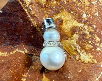 This lot features a 14k gold and pearl snowman pendant with a total approx. weight of 2.00 grams.
