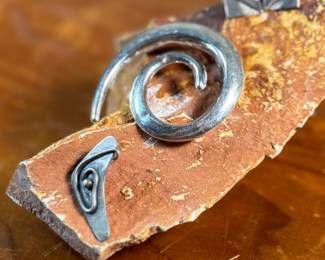 This lot features a collection of modernist sterling silver jewelry including a brooch, a pendant, and a pair of earrings with a total approx. weight of 18.70 grams.

