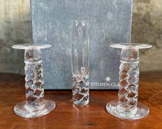 This lot features four (4) pieces of Steuben “twist”, including a pair of candlesticks, a vase, & a bowl. Comes with one large box to store them in. 
