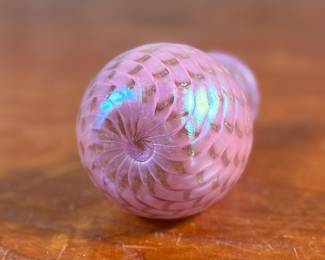 This lot features a stunning vintage pink iridescent vase by Glass Eye Studio, circa 1985. Signed MSH (Mt. Saint Helens) and measures, 4” H x 2.5” W x 2.5” D. Founded in 1978 by a group of glass artist friends, Glass Eye Studio’s first hotshop was nestled in an alley of Seattle’s Pike Place Market. Since its inception over 40 years ago, it continues to thrive with the same passion and revelry for all things glass. As one of the oldest and largest privately-owned hot shops in the country, it’s rich artistic legacy has incubated generations of artists, including some of the most famed glass artists of the Pacific Northwest.
