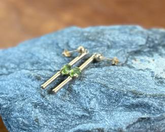 This lot features a pair of stunning 14k gold earrings, each with a Peridot stone and a total approx. weight of 1.12 grams.
