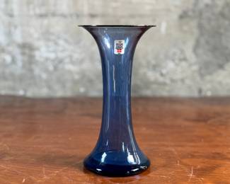 This lot features a vase from the Danish glassworks company, Holmegaard. The company was founded in 1825 and is known for its high-quality glassware. This vase is in very good condition, no chips.
