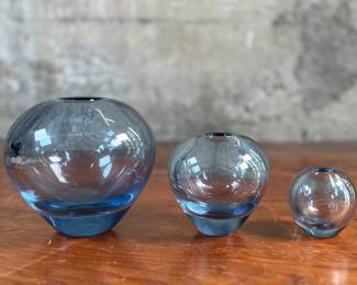 This lot features a set of Holmegaard Rondo vases designed by Per Lütken in aqua blue glass. All three are signed and in good overall condition.
