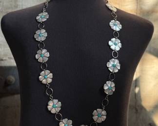 This lot features a vintage Zuni Native American concho belt made of sterling silver with mother-of-pearl and turquoise inlay with a floral design. Measures 42” with a total approx. weight of 196.41 grams.
