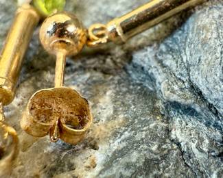 This lot features a pair of stunning 14k gold earrings, each with a Peridot stone and a total approx. weight of 1.12 grams.

