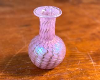 This lot features a stunning vintage pink iridescent vase by Glass Eye Studio, circa 1985. Signed MSH (Mt. Saint Helens) and measures, 4” H x 2.5” W x 2.5” D. Founded in 1978 by a group of glass artist friends, Glass Eye Studio’s first hotshop was nestled in an alley of Seattle’s Pike Place Market. Since its inception over 40 years ago, it continues to thrive with the same passion and revelry for all things glass. As one of the oldest and largest privately-owned hot shops in the country, it’s rich artistic legacy has incubated generations of artists, including some of the most famed glass artists of the Pacific Northwest.
