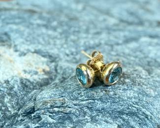 This lot features a pair of beautiful antique 14k gold earrings, each with a center stone that appears to be blue topaz and a total approx. weight of 2.05 grams.
