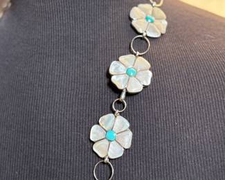 This lot features a vintage Zuni Native American concho belt made of sterling silver with mother-of-pearl and turquoise inlay with a floral design. Measures 42” with a total approx. weight of 196.41 grams.
