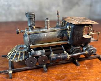 This lot features a unique handcrafted locomotive sculpture made of various metals and salvaged materials. It has a brass plaque mounted on top from Jacksonville, Oregon. This sculpture measures, 6” H x 13” W x 5” D.
