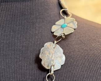 This lot features a vintage Zuni Native American concho belt made of sterling silver with mother-of-pearl and turquoise inlay with a floral design. Measures 42” with a total approx. weight of 196.41 grams.
