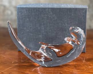 This lot features a Steuben Crystal Glass sea otter figurine, designed by James Houston in 1978. Comes with a Steuben box for storage.
