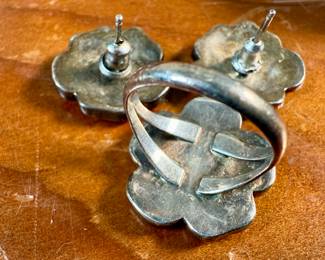 This lot features a vintage set of Zuni Native American jewelry including a bracelet cuff, earrings, and a ring made of sterling silver. The cuff has one inlay piece missing as shown in photos. The ring is a size 5, and the set has a total approx. weight of 57.05 grams. 
