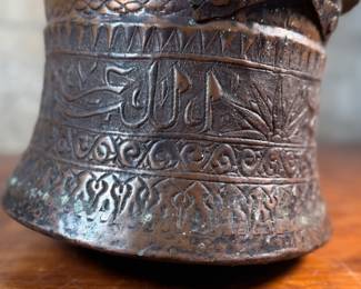 This lot features an antique etched copper cauldron, likely Turkish and from the 19th century. This piece measures, 9” H x 10” W x 10” D.
