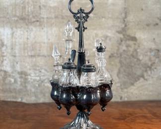 This lot features an antique Meriden Brittania cruet, with maker marks underneath as shown in photos. This cruet has seven (7) misc. containers included, some of which appear to have silver accents. Measures, 18” H x 8” W x 8” D.
