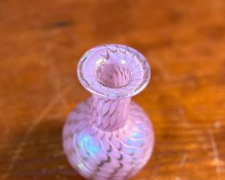 This lot features a stunning vintage pink iridescent vase by Glass Eye Studio, circa 1985. Signed MSH (Mt. Saint Helens) and measures, 4” H x 2.5” W x 2.5” D. Founded in 1978 by a group of glass artist friends, Glass Eye Studio’s first hotshop was nestled in an alley of Seattle’s Pike Place Market. Since its inception over 40 years ago, it continues to thrive with the same passion and revelry for all things glass. As one of the oldest and largest privately-owned hot shops in the country, it’s rich artistic legacy has incubated generations of artists, including some of the most famed glass artists of the Pacific Northwest.
