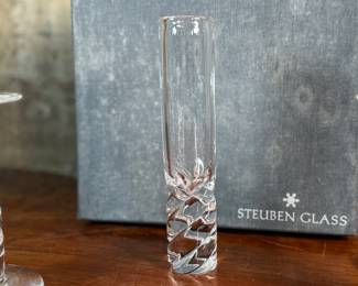 This lot features four (4) pieces of Steuben “twist”, including a pair of candlesticks, a vase, & a bowl. Comes with one large box to store them in. 
