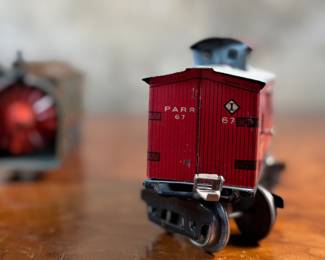 This lot features a collection of three (3) vintage toy train cars, most likely manufactured by Ives Railway Lines. One is marked, “Germany” underneath as shown in photos. All of them appear to be O gauge models.
