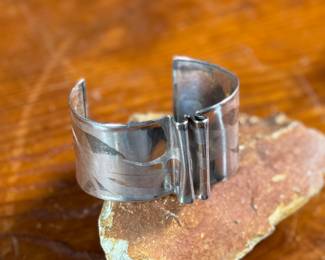 This lot features an artisan made sterling silver cuff, signed by "Cela" as shown in photos with a total approx. weight of 27.33 grams.

