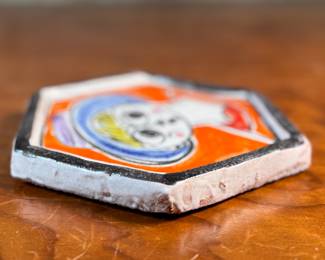 This lot features a stunning hand-painted hexagonal ceramic plate by listed Italian artist, Giovanni De Simone, circa 1960s. This piece measures, 6.25” H x 7” W. De Simone’s work is known for its vibrant colors and cubist drawing style, which was influenced by artists like Pablo Picasso. The company’s artistic tradition is continued by his daughter, Susanna De Simone. 
