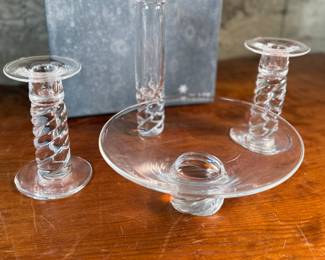 This lot features four (4) pieces of Steuben “twist”, including a pair of candlesticks, a vase, & a bowl. Comes with one large box to store them in. 
