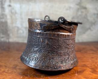 This lot features an antique etched copper cauldron, likely Turkish and from the 19th century. This piece measures, 9” H x 10” W x 10” D.

