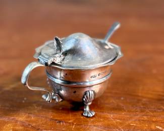 This lot features an antique sterling silver mustard pot with spoon. Marked as shown in photos with a total approx. weight of 62.08 grams.

