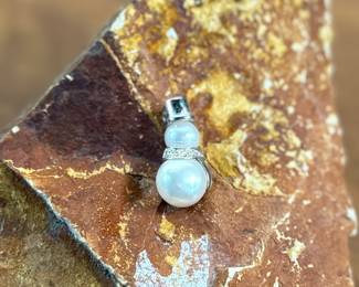 This lot features a 14k gold and pearl snowman pendant with a total approx. weight of 2.00 grams.
