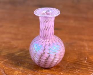 This lot features a stunning vintage pink iridescent vase by Glass Eye Studio, circa 1985. Signed MSH (Mt. Saint Helens) and measures, 4” H x 2.5” W x 2.5” D. Founded in 1978 by a group of glass artist friends, Glass Eye Studio’s first hotshop was nestled in an alley of Seattle’s Pike Place Market. Since its inception over 40 years ago, it continues to thrive with the same passion and revelry for all things glass. As one of the oldest and largest privately-owned hot shops in the country, it’s rich artistic legacy has incubated generations of artists, including some of the most famed glass artists of the Pacific Northwest.
