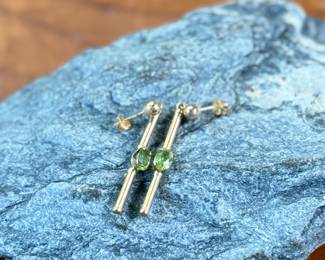 This lot features a pair of stunning 14k gold earrings, each with a Peridot stone and a total approx. weight of 1.12 grams.
